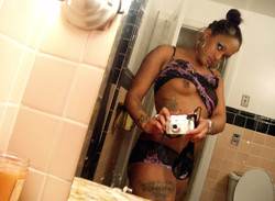 Tattoed young ebony taking pictures of